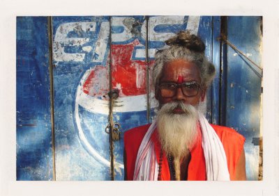 BUBO - 2006 - história - Iba v exotických, málo turistických oblastiach, nachádzame tie najväčšie paradoxy. No globalizácia sa blíži. Na fotografii je svätý muž a za ním pokazené logo Pepsi - aj keď Pepsi Colu tu nedostať.